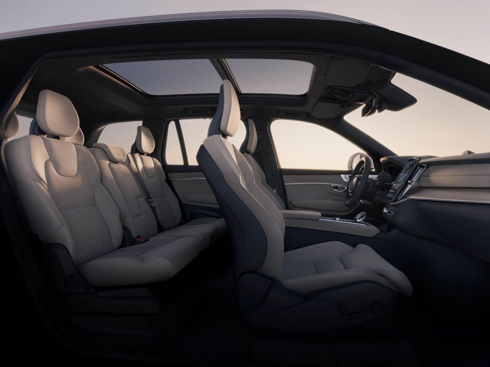 Volvo XC90 — Airy three-row cabin in light leather beneath a full panoramic glass roof