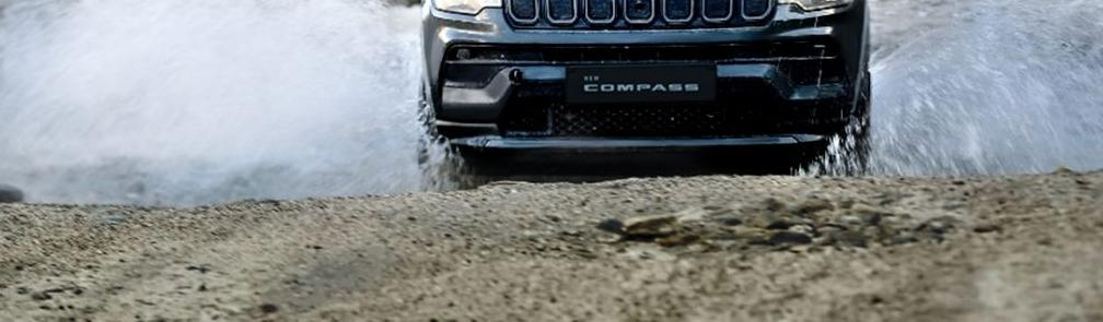 Jeep Compass — Wading through a water crossing, underlining the SUV’s off-road ability.