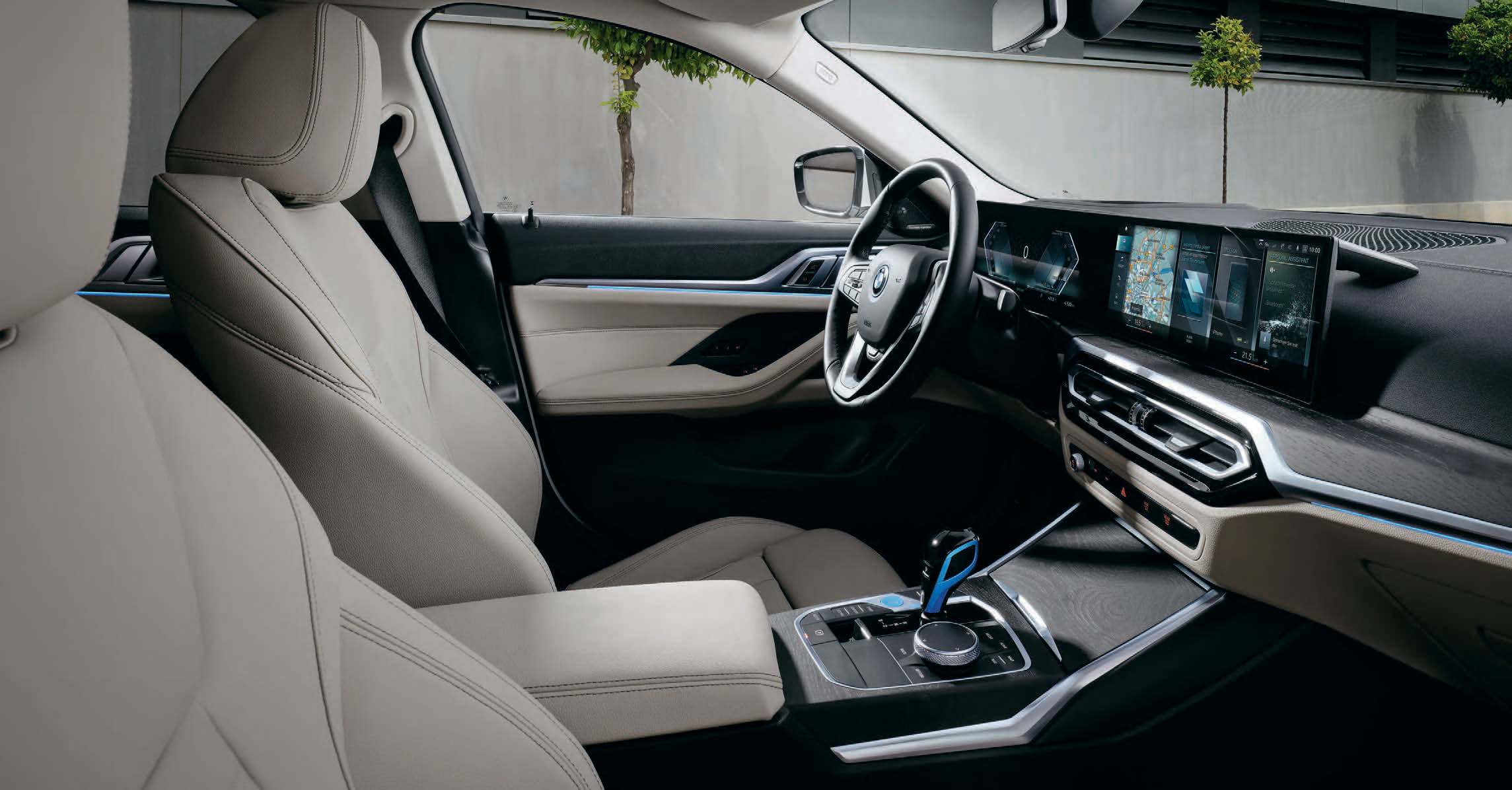 BMW i4 — Driver-oriented cockpit in Oyster leather with the BMW Curved Display, floating centre console and electronic gear selector.