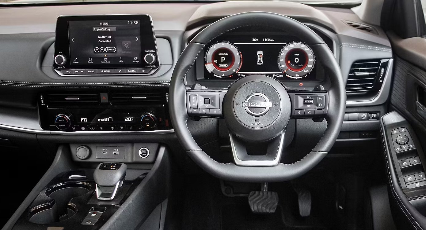 Nissan X-Trail interior showing steering wheel, digital dashboard, and infotainment screen.