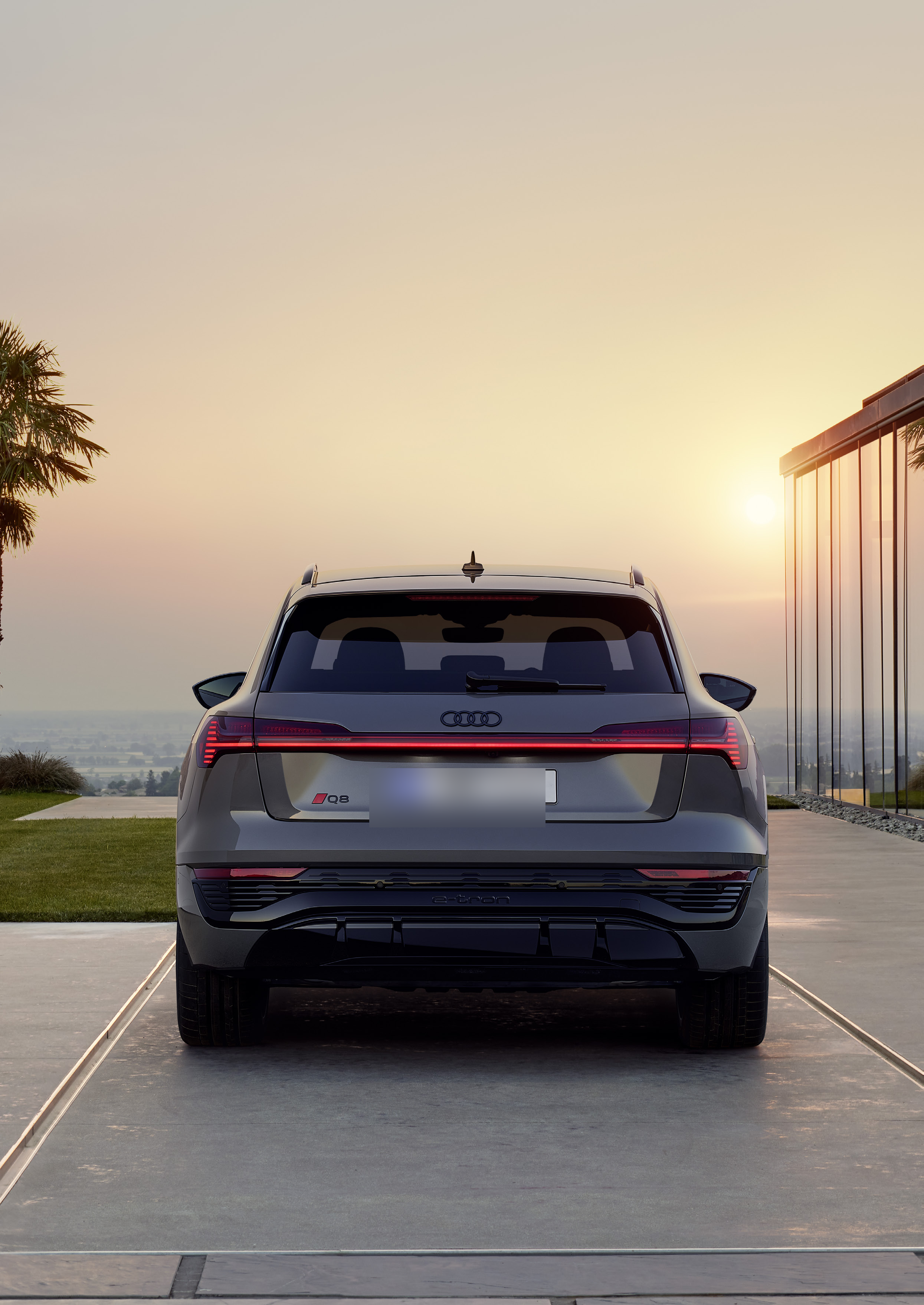 Audi Q8 e-tron — Full-width rear light bar with illuminated Audi rings and connected tail-lamps across the tailgate.