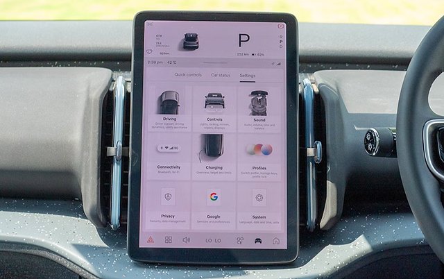 Central touchscreen display in car interior showing vehicle settings and control menu.