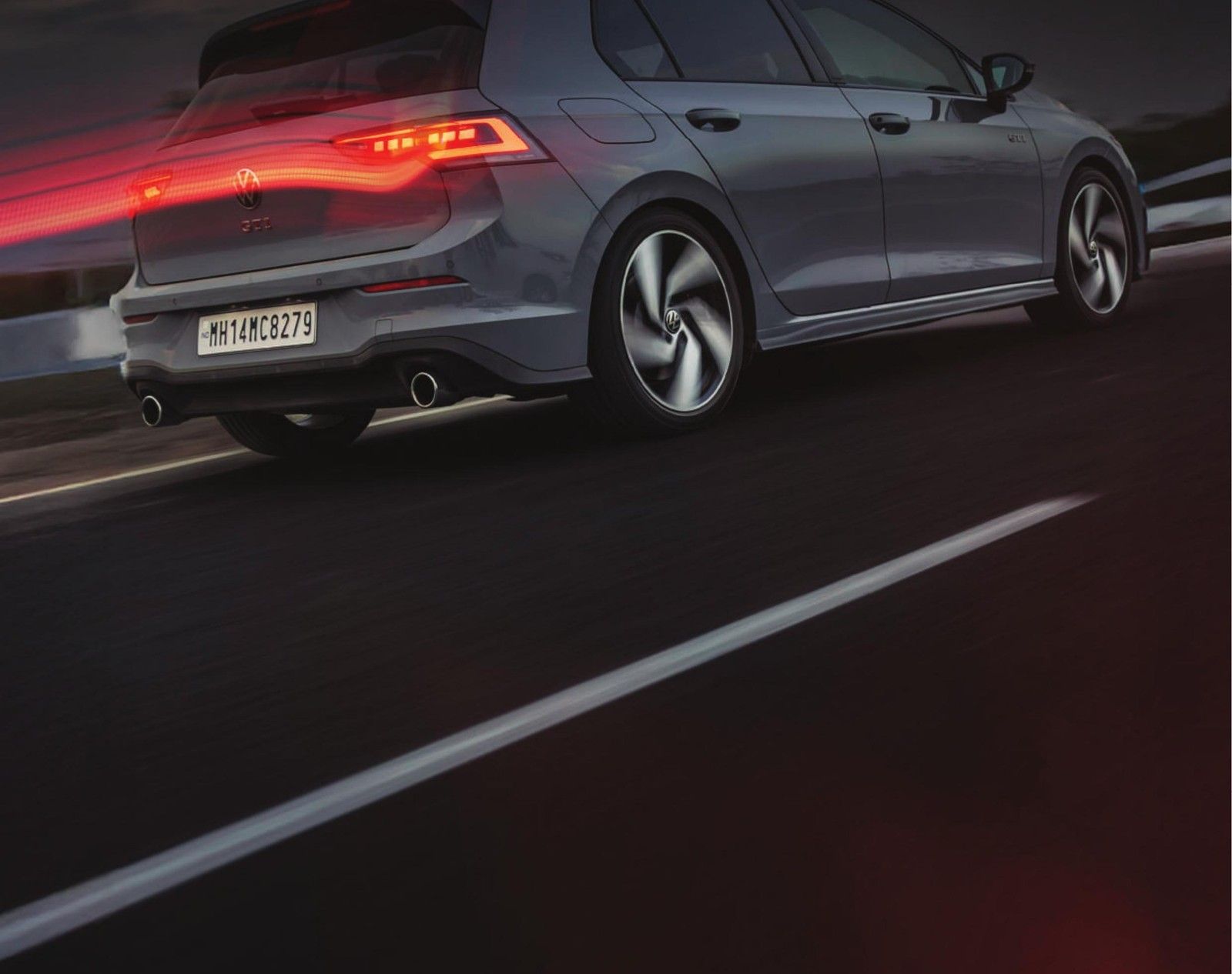Volkswagen Golf GTI — Rear three-quarter view highlighting the GTI's LED tail-lamps, roof spoiler and twin exhaust styling.