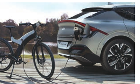 Kia EV6, Vehicle-to-Load (V2L) powers external devices, here charging an e-bike from the EV6's charge port.