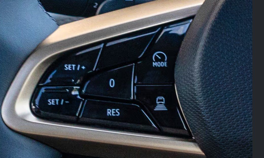 Steering wheel control buttons for cruise control and mode settings in vehicle.