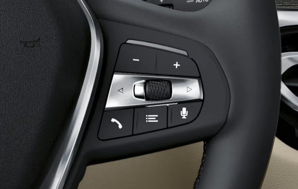 Steering wheel controls with volume, navigation, phone, and voice command buttons.