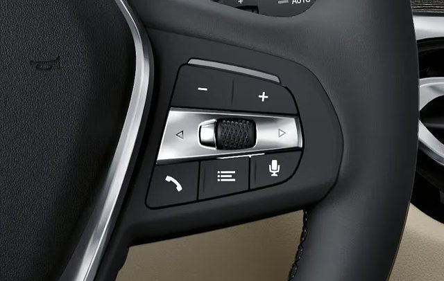 Steering wheel controls with volume, navigation, phone, and voice command buttons.