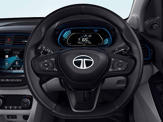 Tata Tigor EV, Fully digital instrument cluster displaying state of charge, range and drive mode, behind a flat-bottom steering wheel with audio, phone and cruise controls