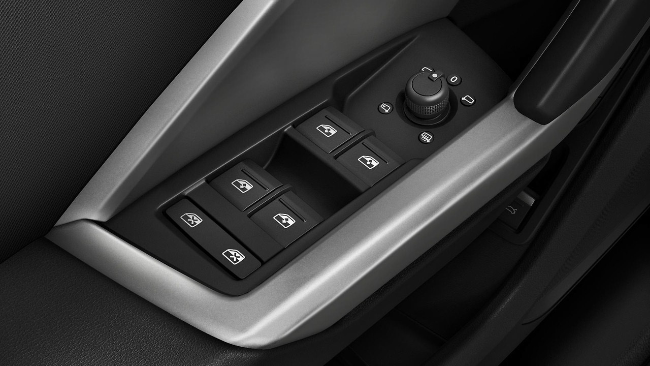 Audi Q3 — Driver-door switch panel with power window controls and rotary mirror-adjust selector.