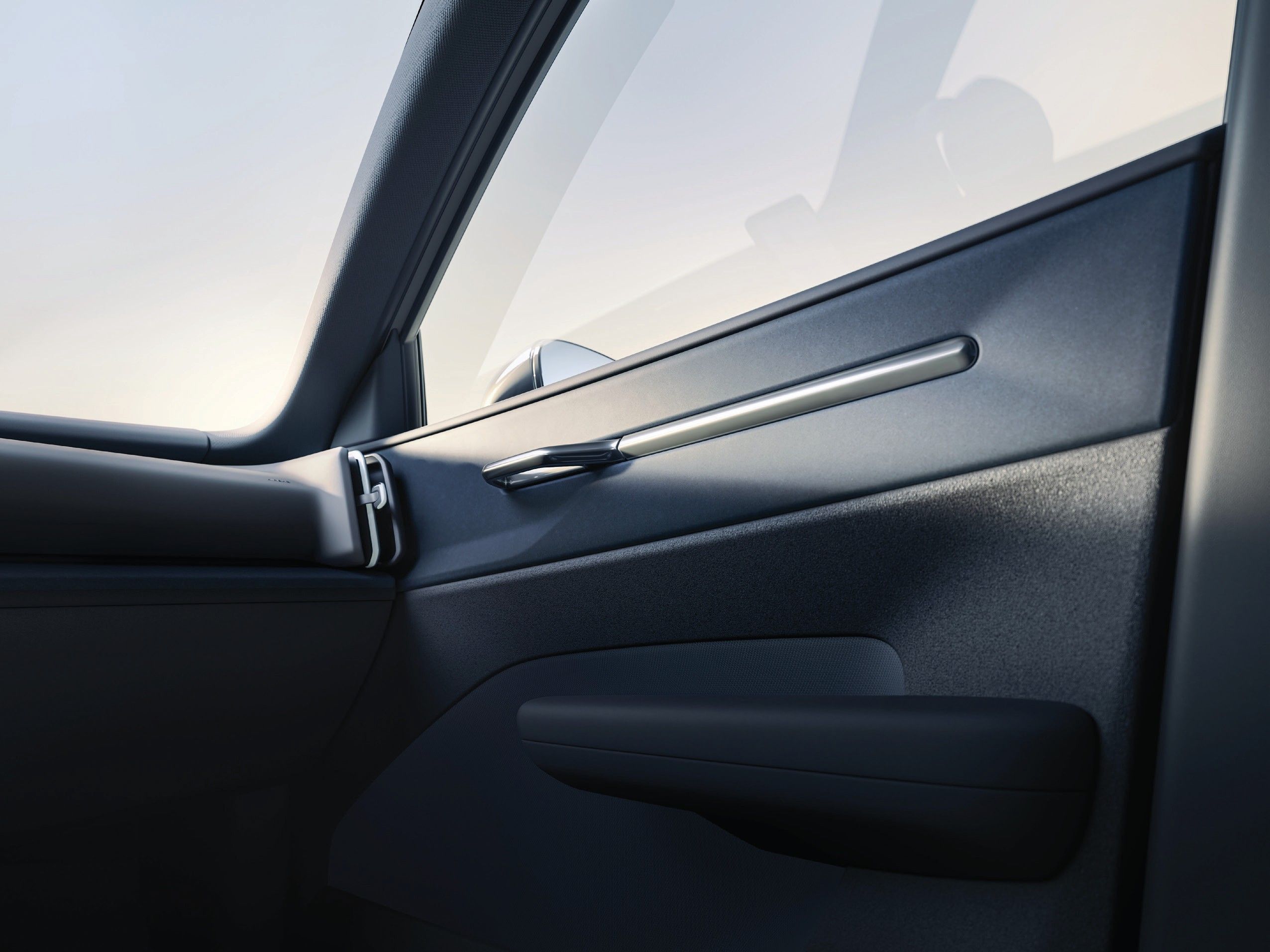 Volvo EX30 — Front door panel detail showing the integrated grab handle, textured trim and door pocket.