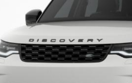Land Rover Discovery — Gloss-black mesh grille with embossed DISCOVERY lettering, flanked by Matrix LED headlights.