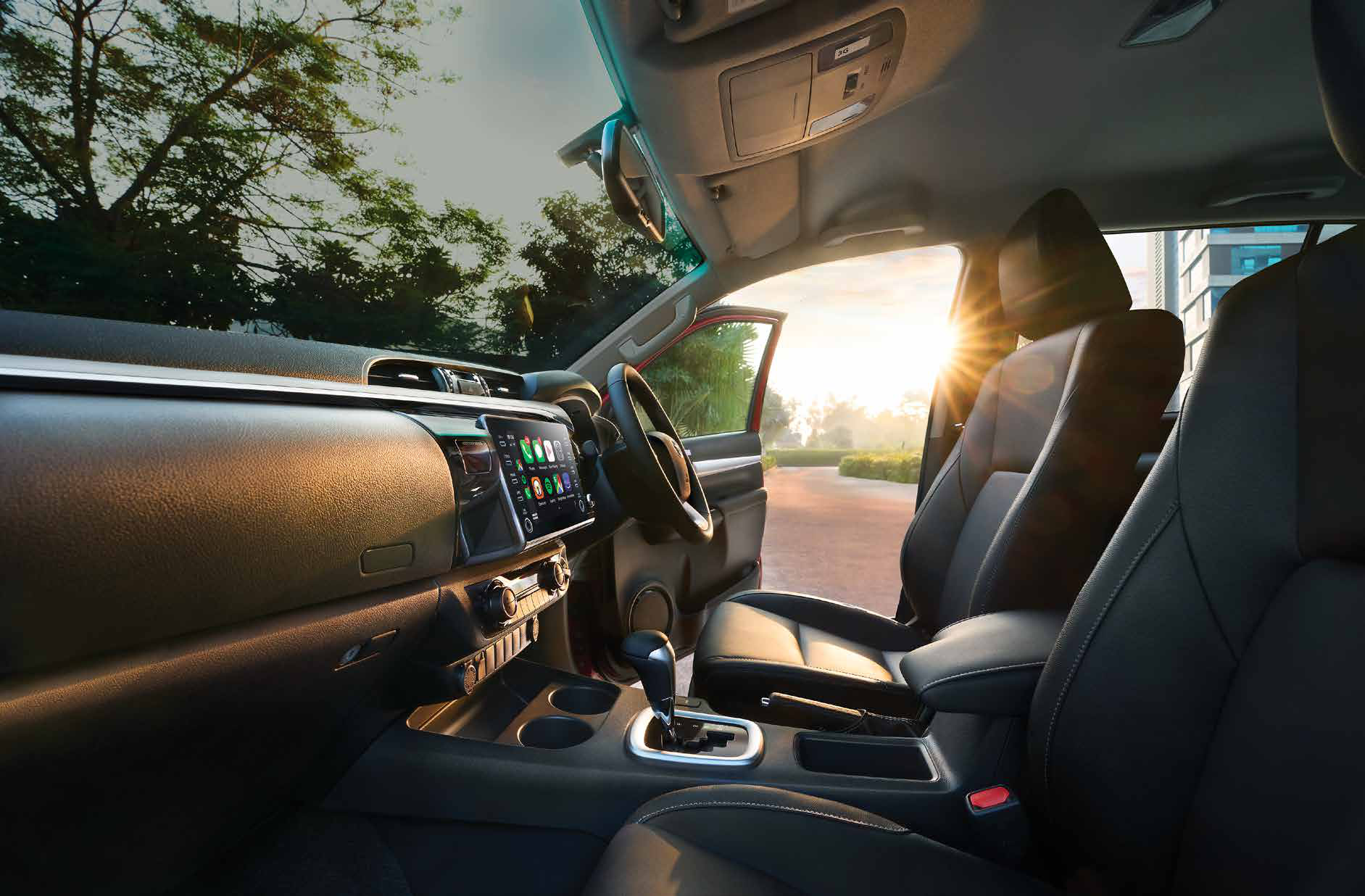 Toyota Hilux — Black leather-trimmed seats with a floating touchscreen and automatic gear selector.