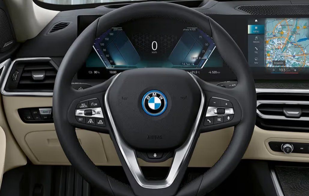 BMW i4 interior showing steering wheel, digital dashboard, and navigation display.