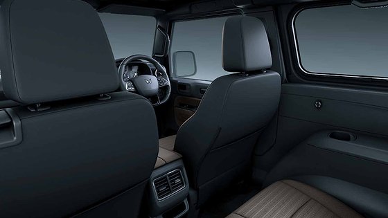 Mahindra Thar OG, Second-row view from inside the cabin: front seatbacks in black with the steering wheel beyond, rear air vents at the ba
