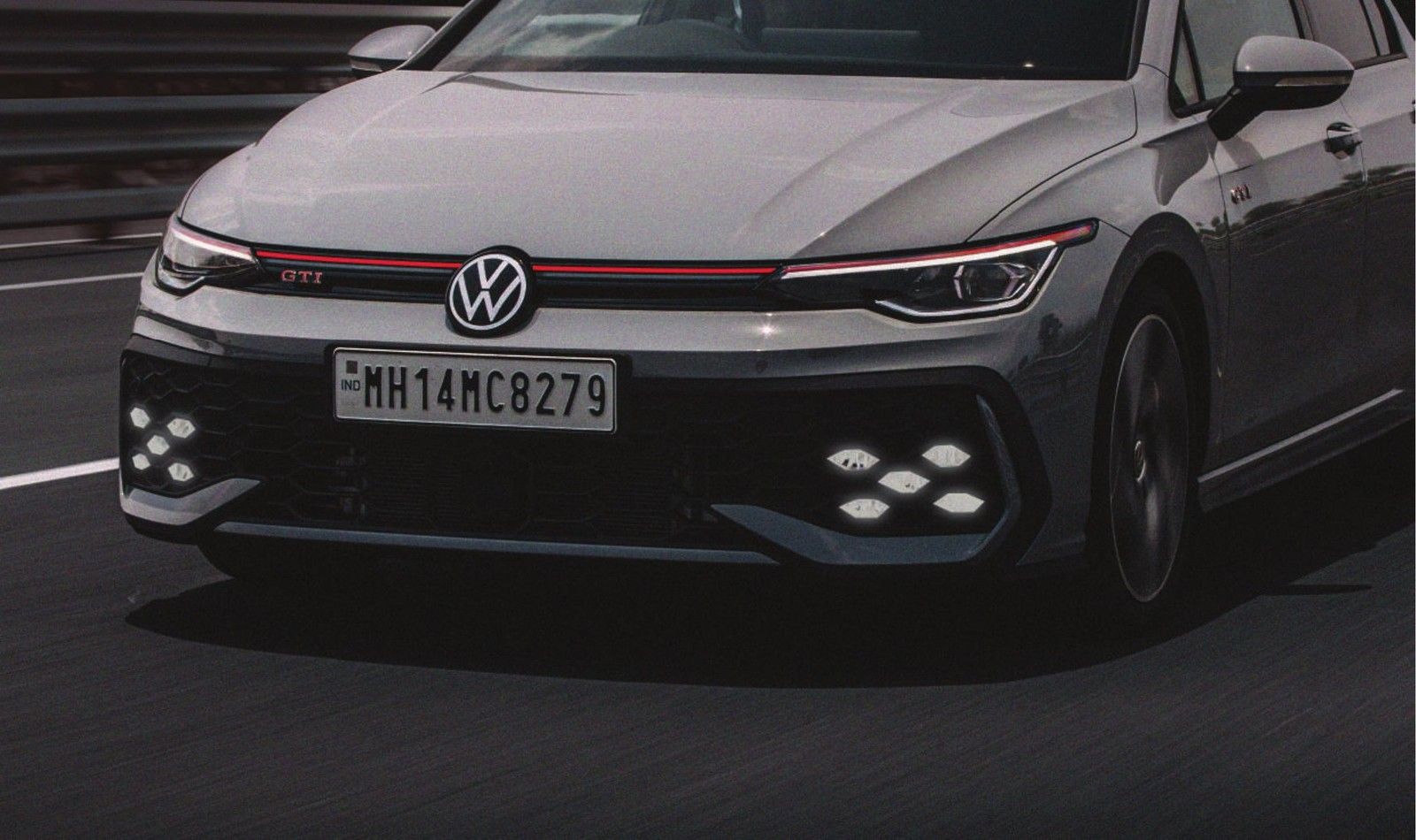 Volkswagen Golf GTI — The Golf GTI's front fascia with the honeycomb grille, signature red strip and X-shaped LED fog-lamp clusters.