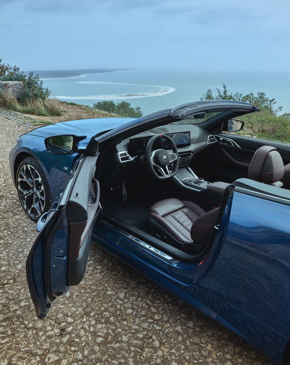 BMW M440i — Driver's sport seat and illuminated M door sill, viewed through the open door.