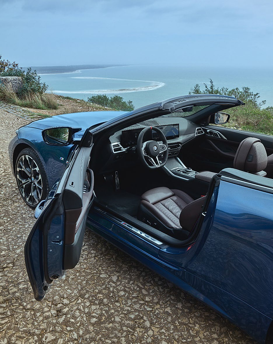 BMW M440i, Driver's sport seat and illuminated M door sill, viewed through the open door.