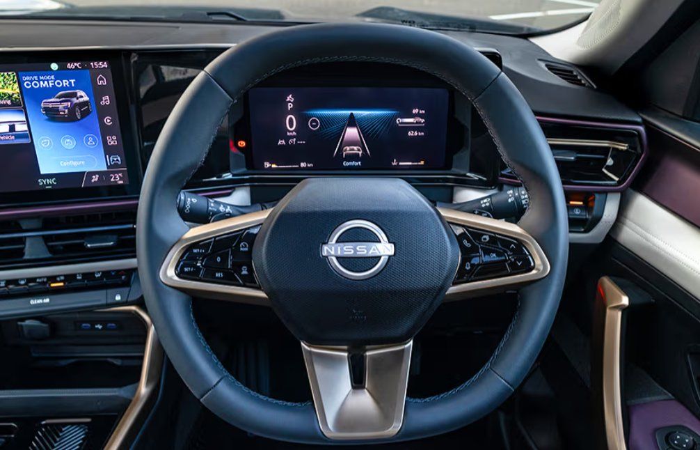 Nissan steering wheel with digital dashboard display and center console infotainment system.