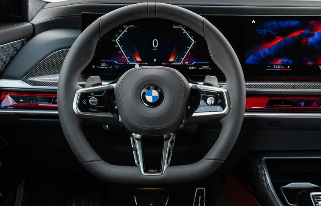 BMW steering wheel with digital dashboard and center infotainment screen in vehicle interior.