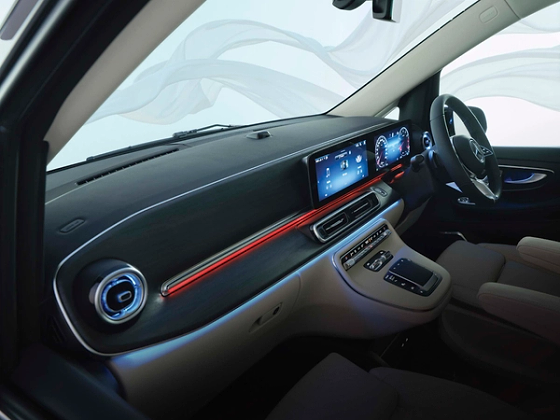 Mercedes-Benz V-Class, Open-pore wood-look trim flowing across the dashboard, paired with the free-standing MBUX media display and a red ambient light strip.