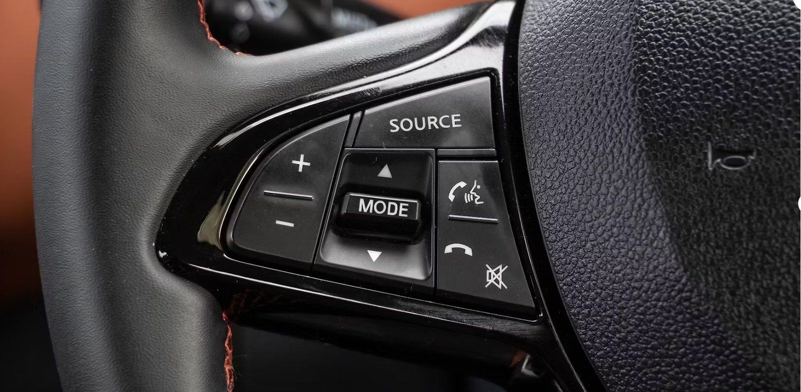 Steering wheel control buttons for audio, phone, and voice commands in dark gray.