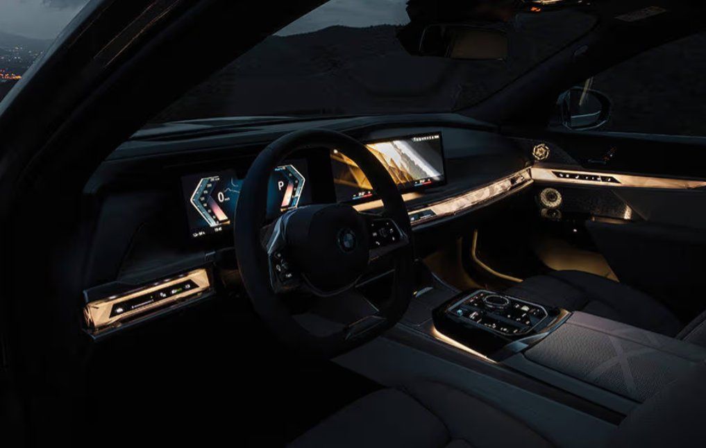 Luxury car interior with illuminated dashboard, steering wheel, and digital displays at dusk.