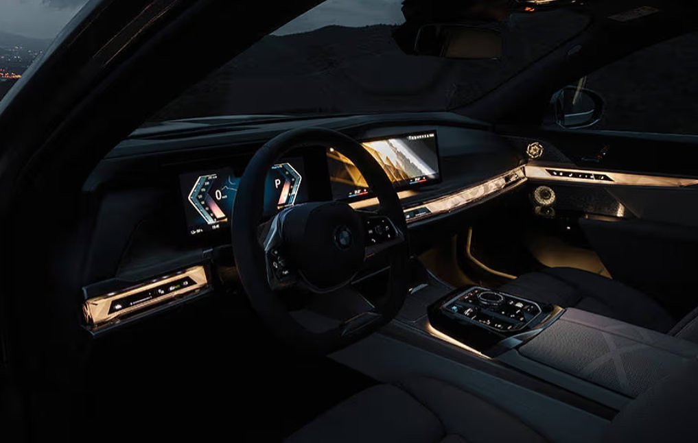 Luxury car interior with illuminated dashboard, steering wheel, and digital displays at dusk.