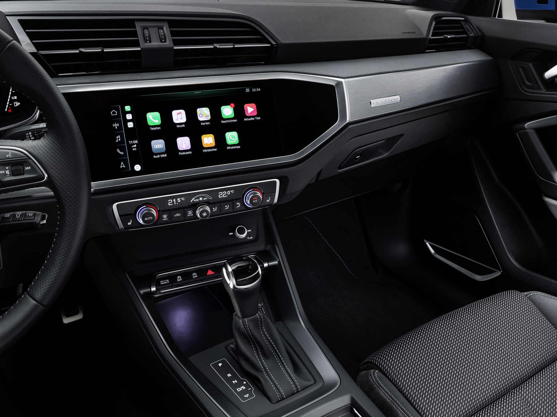 Audi Q3 — MMI touchscreen showing smartphone-mirrored apps above the two-zone climate controls.