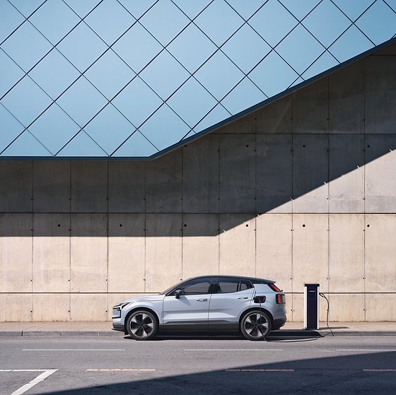 Volvo EX30, The EX30 parked at a wall-mounted charging station with the charging cable connected.