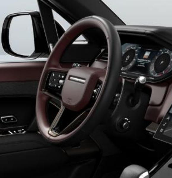 Land Rover Range Rover Sport — Leather multifunction steering wheel with brushed-metal spoke inlay, set beside the curved digital driver display.