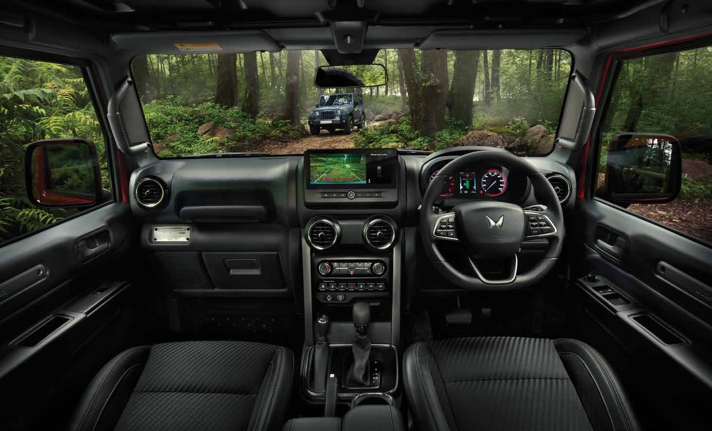 Mahindra Thar OG, Same wide front-cabin view as the other cabin shot, but with the touchscreen displaying a green reversing-camera image w