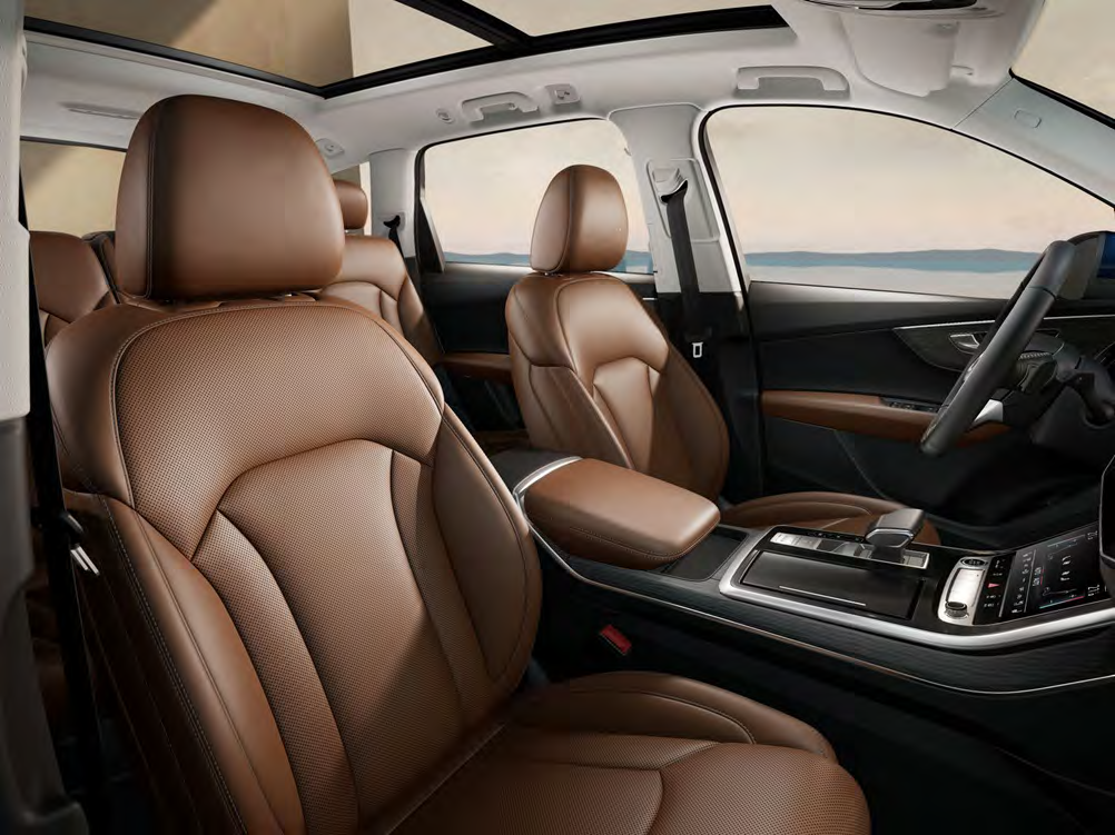 Audi Q7 — Front seats trimmed in brown leather beneath the open panoramic sunroof