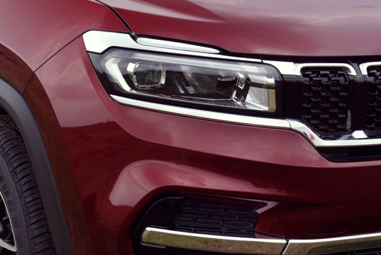 Jeep Meridian — Dual-LED headlamp with a chrome-accented brow, set beside the seven-slot grille.