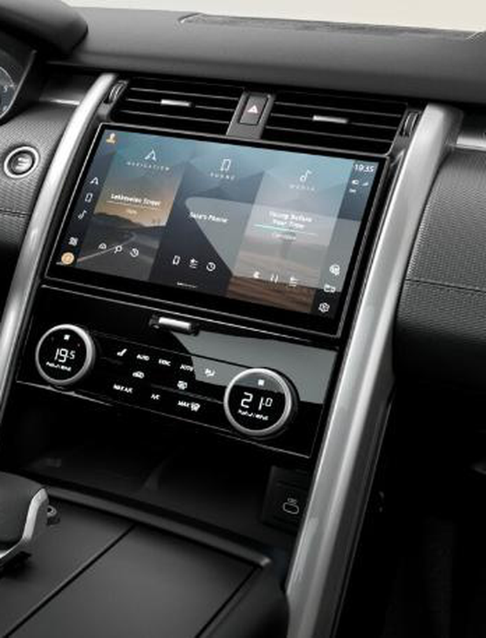 Land Rover Discovery — Central touchscreen infotainment with Navigation, Phone and Media, above twin-dial Three-zone Climate Control.