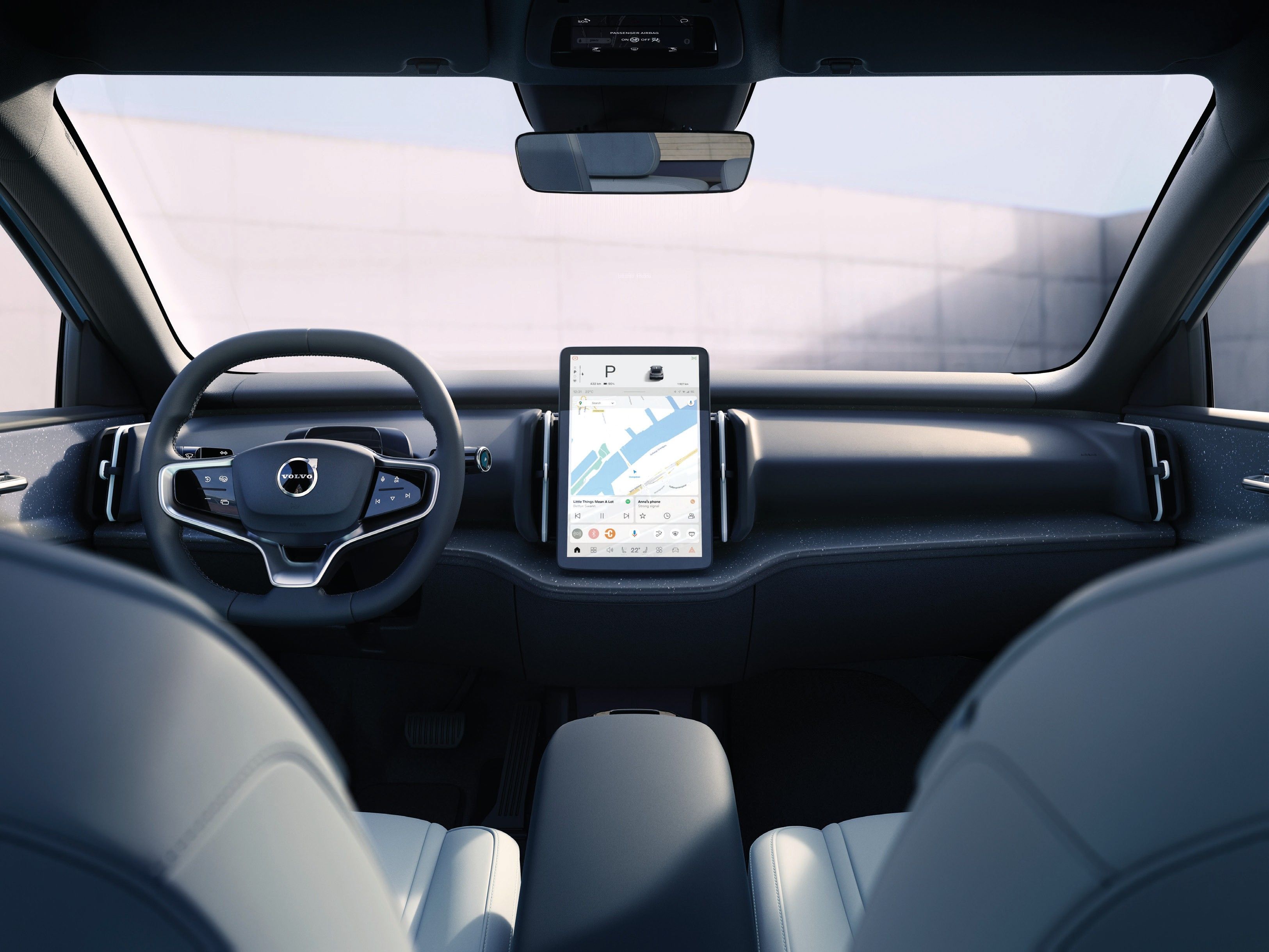 Volvo EX30 — Front cabin view with the two-spoke steering wheel, centre-mounted vertical touchscreen and light-upholstered front seats.