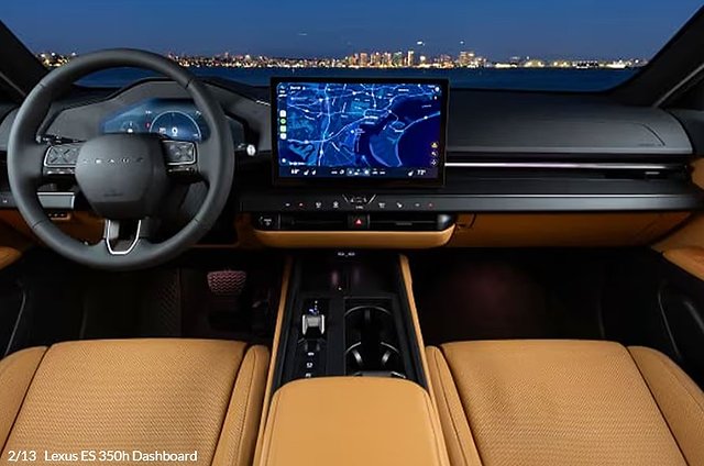 Luxury car interior with tan leather seats, steering wheel, and navigation display at night.