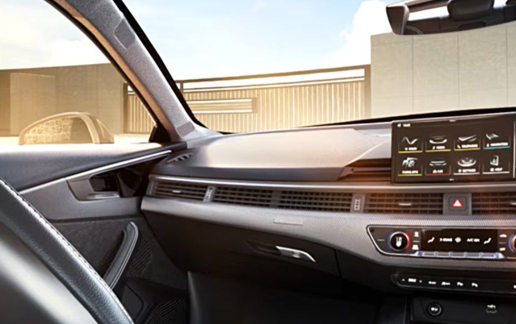 Modern car interior with digital dashboard, steering wheel, and climate controls visible.