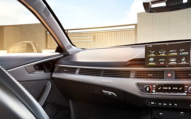 Modern car interior with digital dashboard, steering wheel, and climate controls visible.