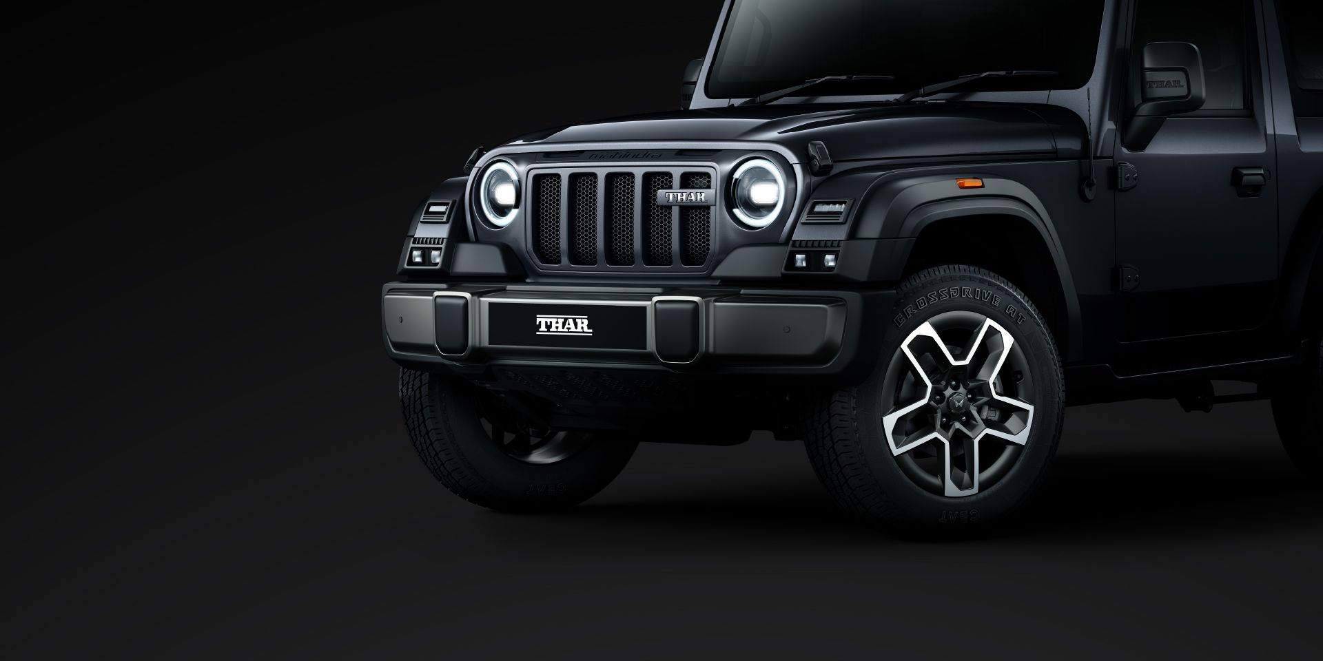 Mahindra Thar OG front three-quarter with the lamps lit
