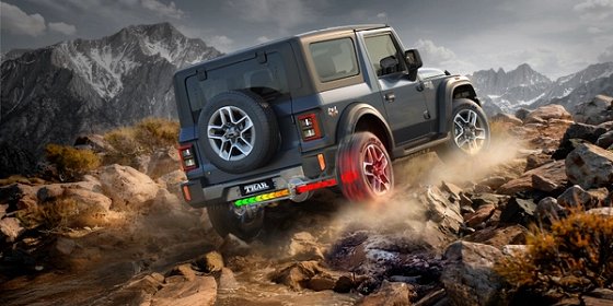 Mahindra Thar OG, Rear three-quarter view of a blue-grey Thar OG climbing a boulder field in the mountains, with one rear wheel graphicall