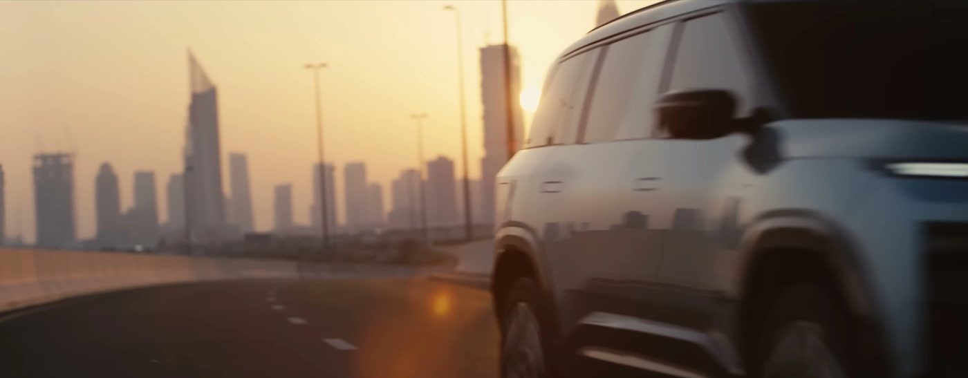 Tata Sierra.ev cruising past the Dubai skyline at sunset, side profile silhouette