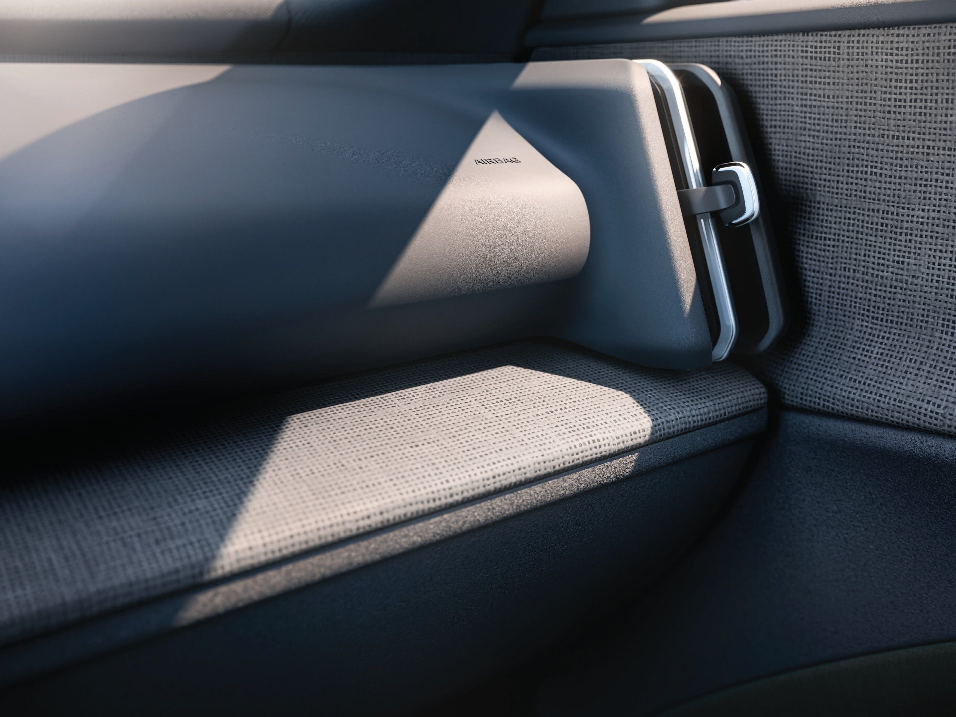 Volvo EX30 — Rear seat and door detail showing the woven textile upholstery and slim armrest.