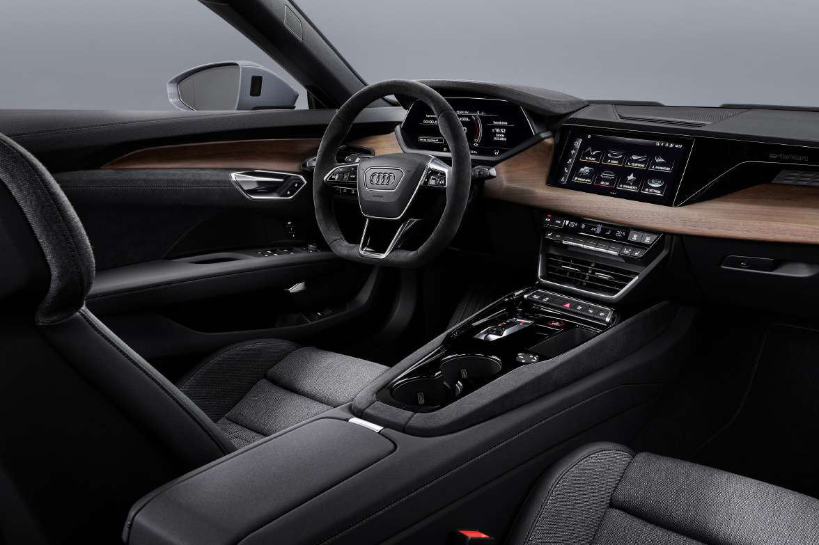 Audi e-tron GT — Driver-focused cabin with Alcantara steering wheel, digital cockpit, MMI touch display and open-pore wood inlays