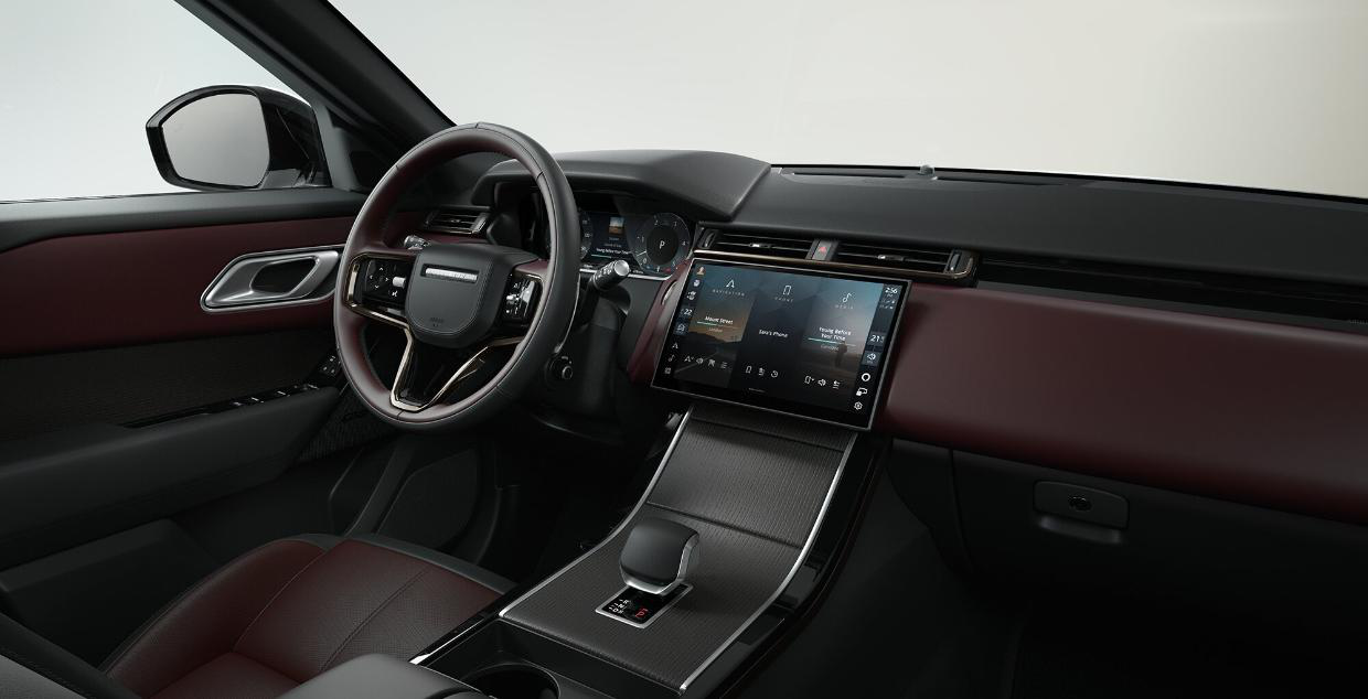 Land Rover Range Rover Velar — Driver-focused cabin with a curved-glass Pivi Pro touchscreen and digital driver display.