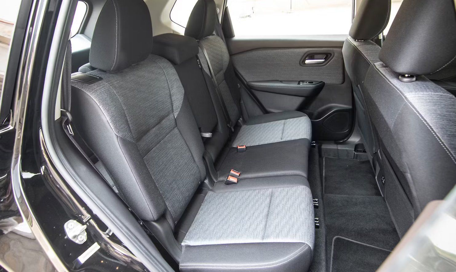Rear interior of black SUV with gray and black upholstered seats and door panels.