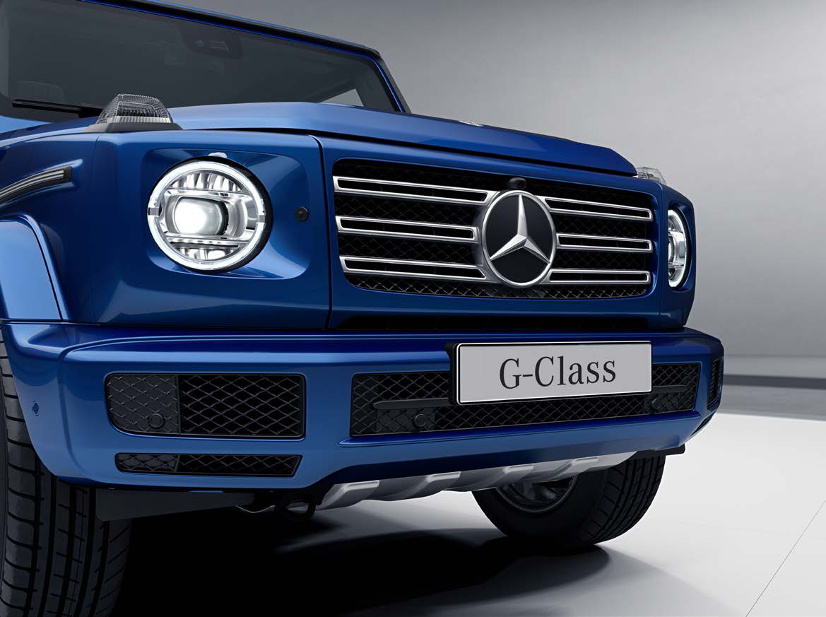 Mercedes-Benz G-Class — Round LED headlamp with the signature G-Class daytime running light ring, beside the upright chrome radiator grille