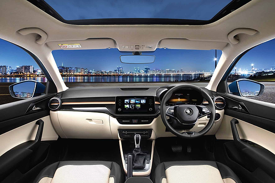 Skoda Škoda Slavia (2022–2026), Stone Beige and Piano Black dashboard with an electric sunroof opening to a panoramic cabin view.