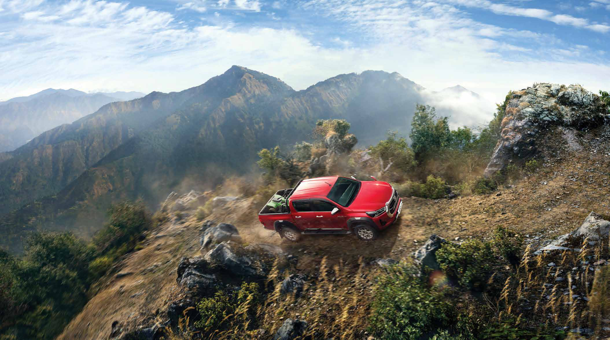 Toyota Hilux — Four-wheel-drive capability climbing a rugged mountain trail.