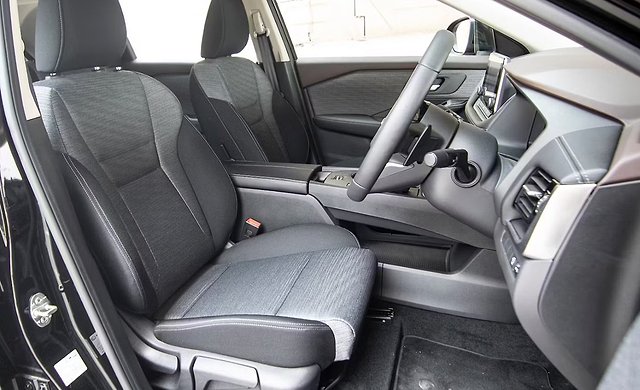 # Alt text:
Car interior with gray fabric seats, steering wheel, and dashboard visible.