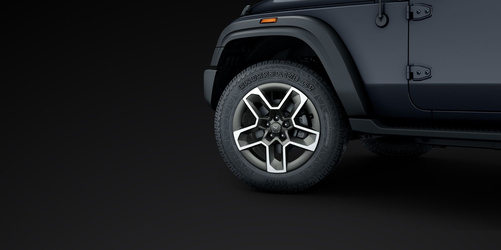 Mahindra Thar OG, Close-up of the front wheel on a grey Thar OG: five-spoke machined-face alloy wheel with an all-terrain tyre marked CROS